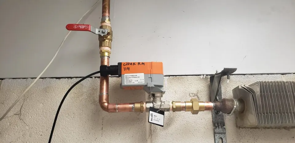 Motorized zone valve on copper piping feeding a hydronic heater