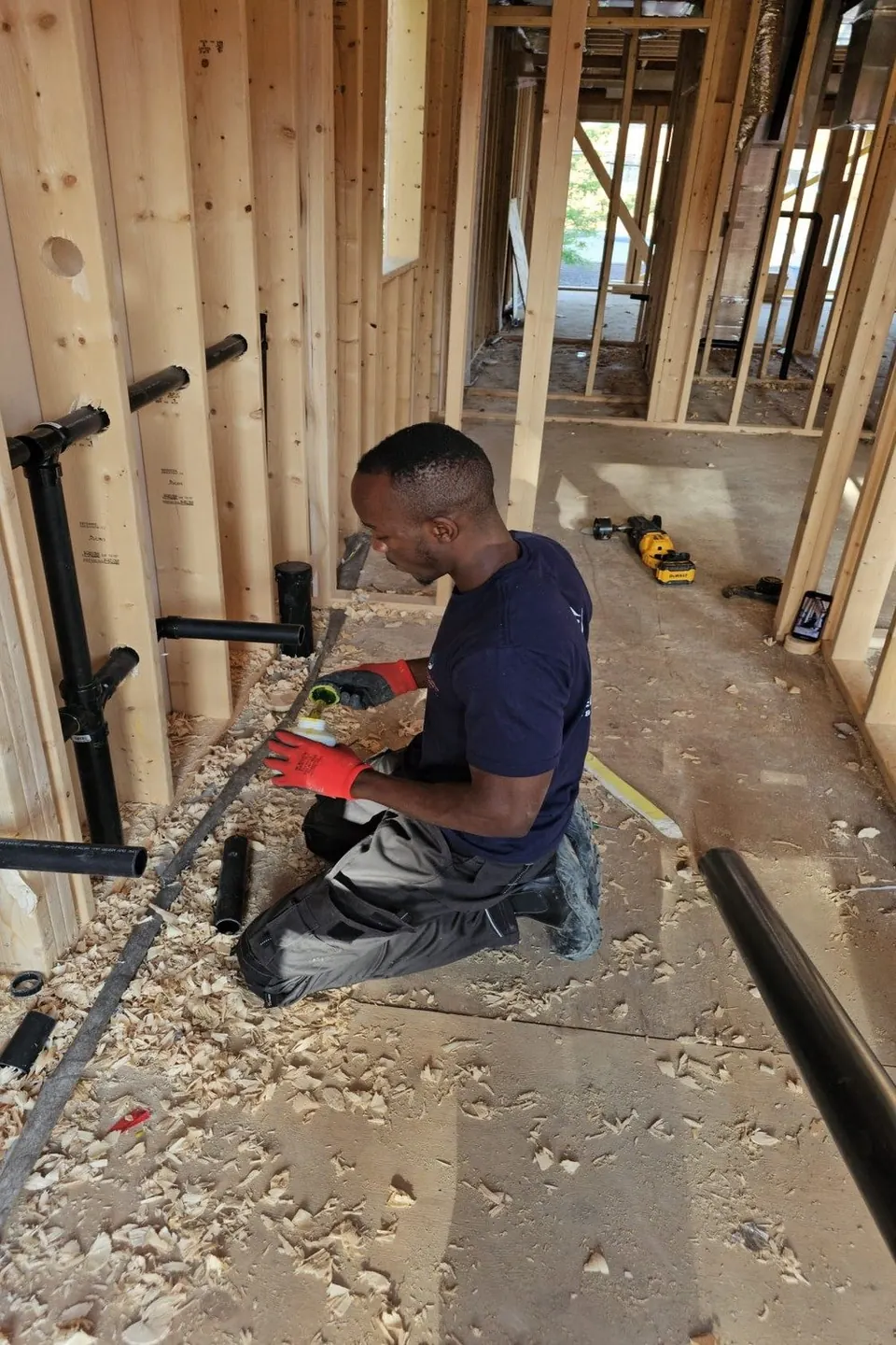 GiftedHands plumber installing drain rough-in on a new construction site