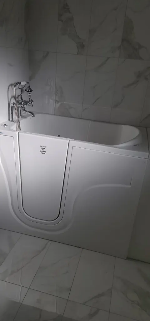 Walk-in bathtub installed in a marble-tile bathroom